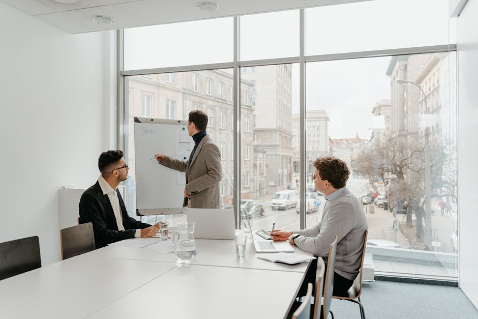 Three professionals engaged in a business meeting in a bright conference room.